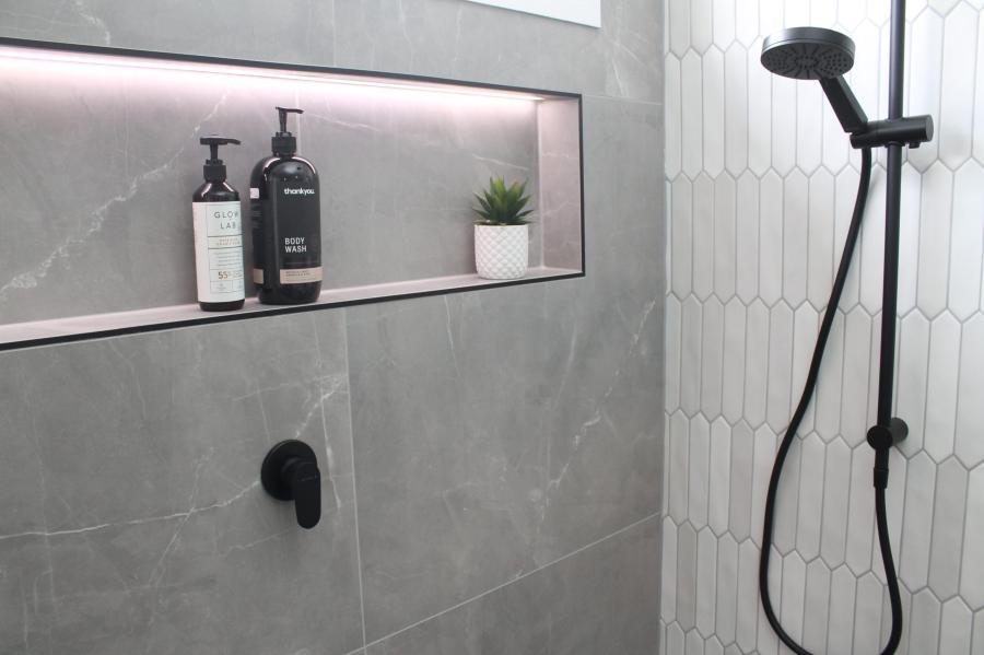 Modern grey tiled shower with recessed niche and matte black shower fittings