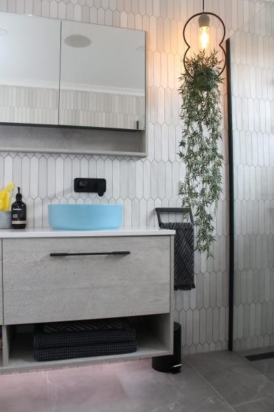 Modern bathroom vanity with blue basin, mirrored cabinet and vertical white wall tiles