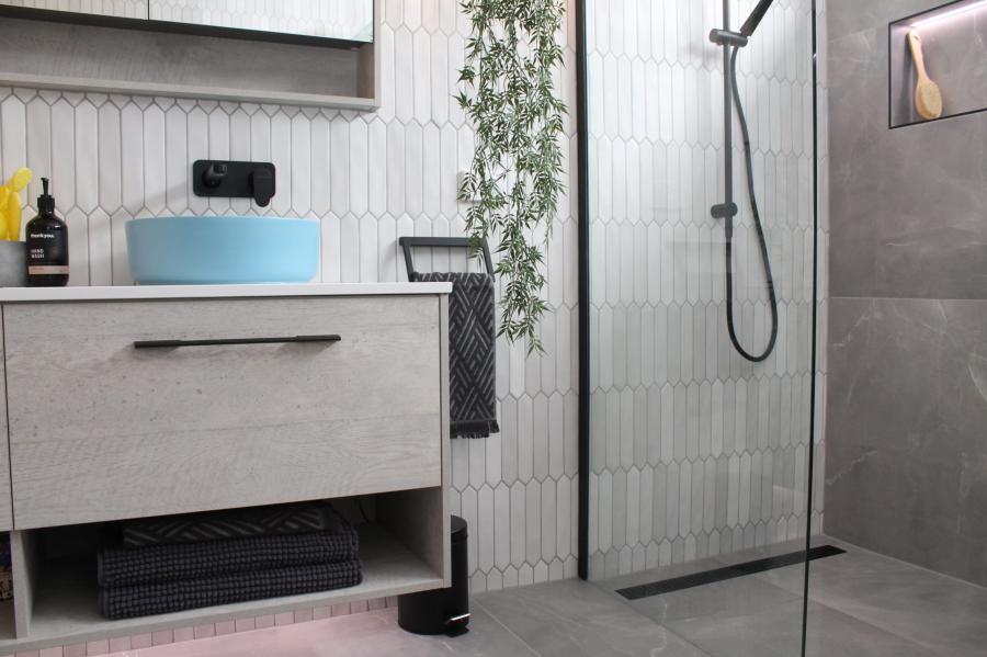Modern bathroom vanity and walk-in shower with grey tiles