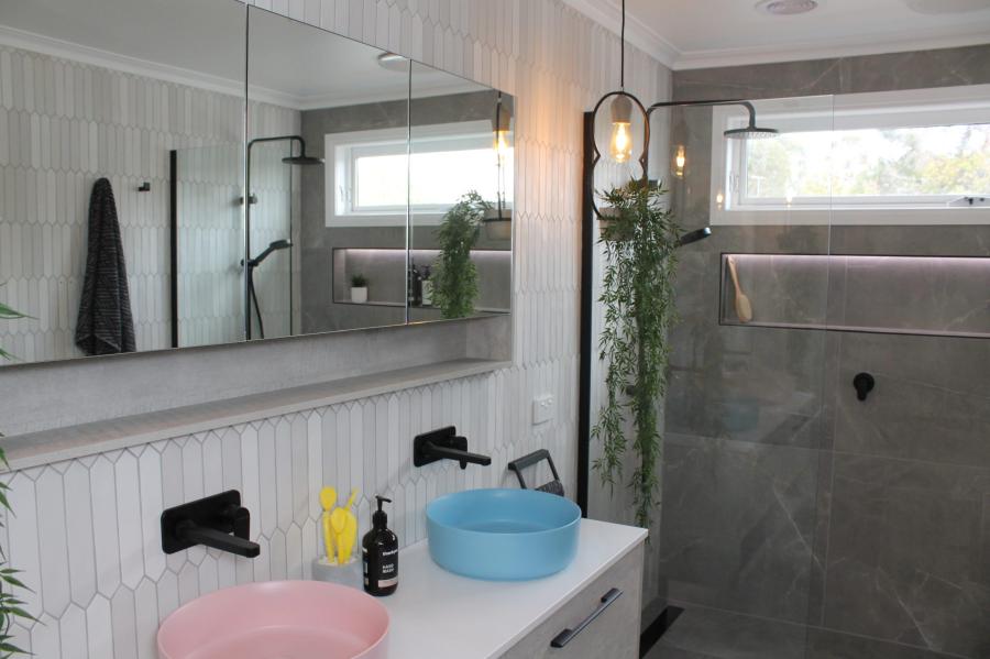 Modern bathroom vanity with pastel basins and walk-in shower