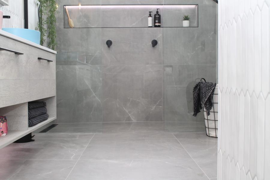 Modern grey walk-in shower with niche shelving and floating vanity