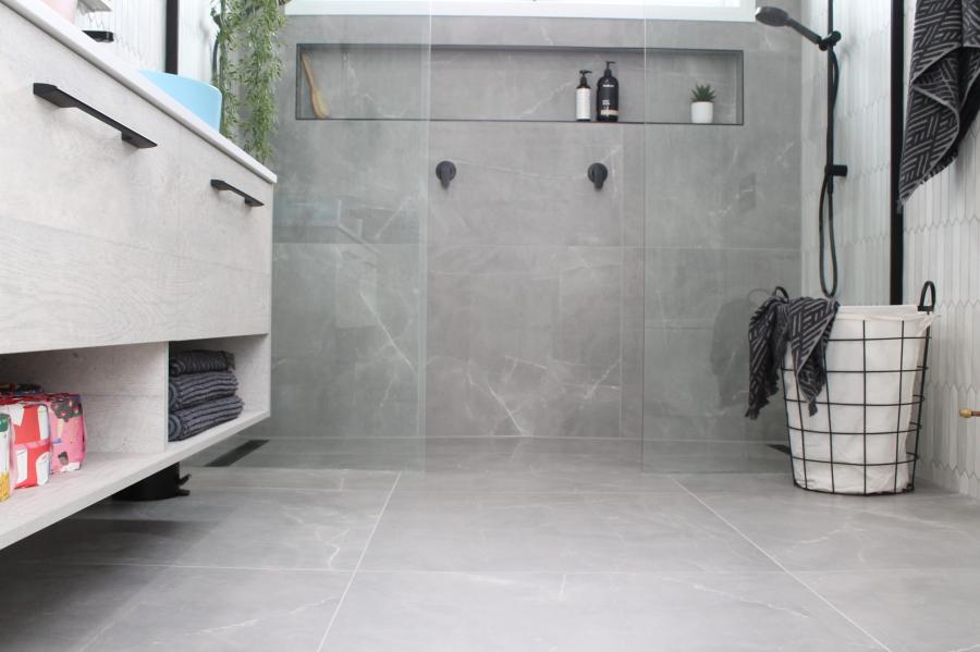 Modern grey tiled bathroom with walk-in shower, recessed niche and floating vanity