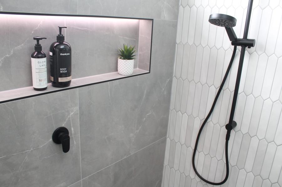 Modern shower with recessed niche, grey tiles and matte black shower rail