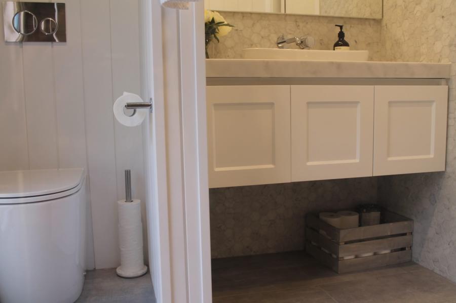 View from toilet area into a bathroom with floating vanity and integrated basin