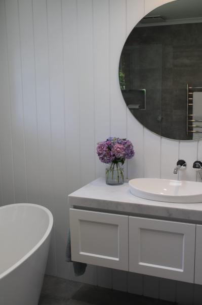Modern bathroom with freestanding bath, floating vanity and round mirror