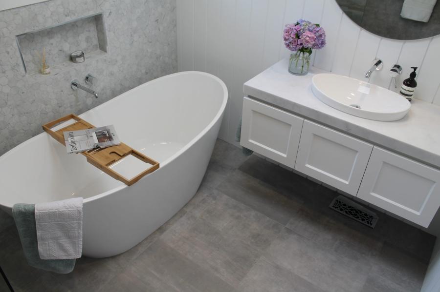 Modern white bathroom with freestanding bath, vanity and grey floor tiles