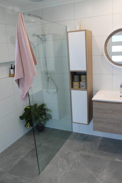 Modern white tiled bathroom with frameless glass shower and floating vanity