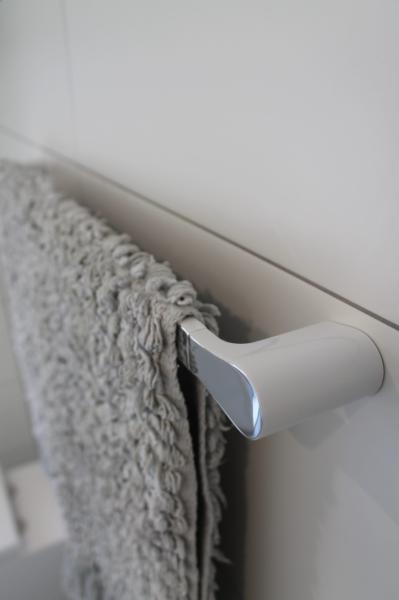 Close-up of a grey textured towel hanging on a modern white bathroom towel rail