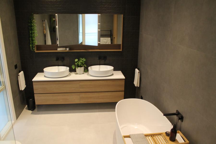 Modern bathroom with floating timber vanity, double basins, freestanding bath and dark feature walls