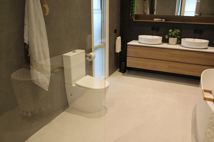 Modern bathroom with freestanding bath, toilet and timber floating vanity
