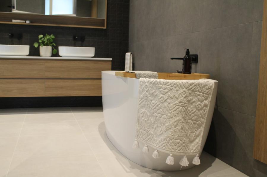 Freestanding white textured bathtub with tassel detail in a modern bathroom