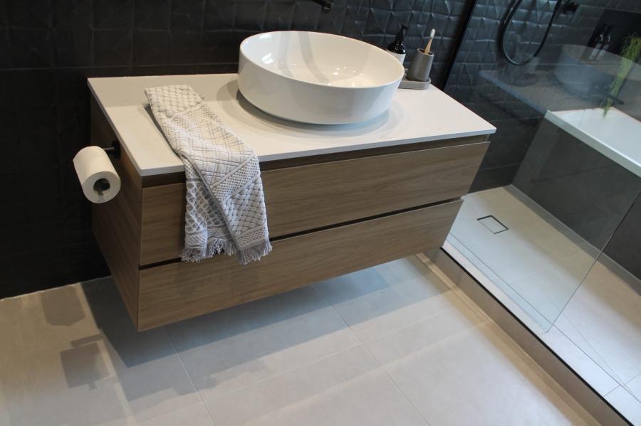 Floating timber vanity with round basin beside a walk-in shower in a modern bathroom