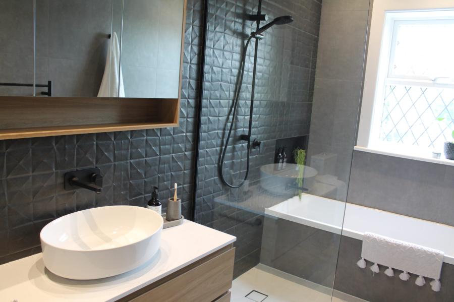 Modern grey bathroom with vessel basin, walk-in shower, bathtub and timber vanity