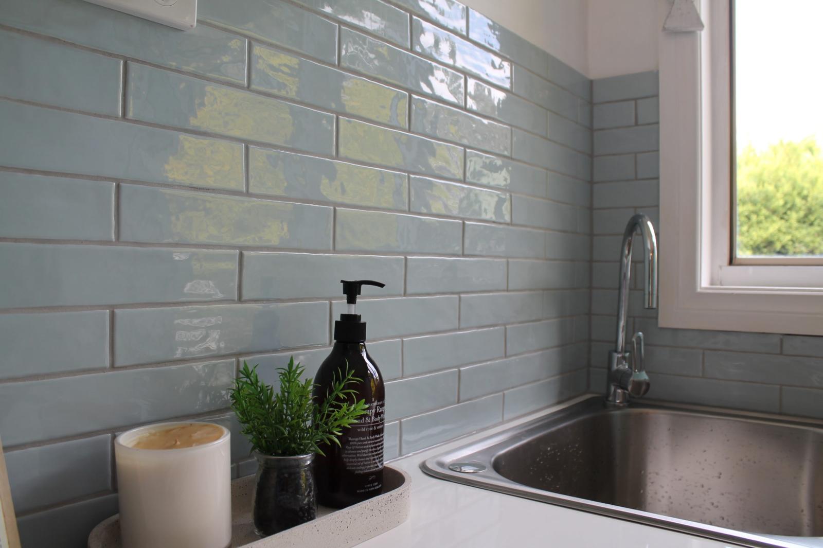 Modern kitchen sink with grey subway tiles and black dispenser