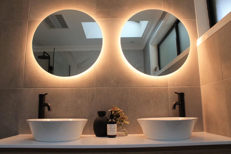 Modern double vanity with round backlit mirrors and matte black tapware