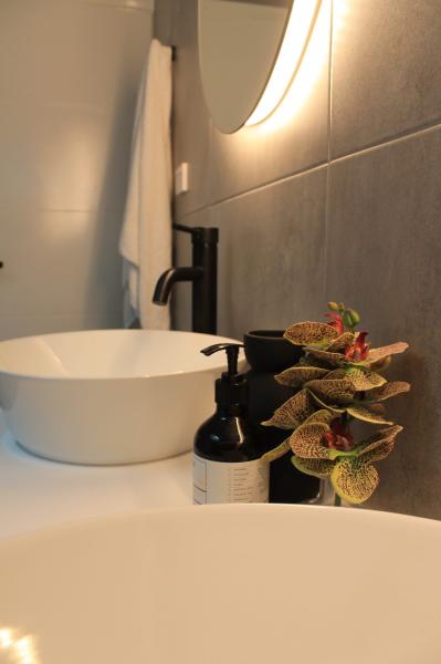 Modern bathroom vanity with vessel basin, black tapware and soft lighting