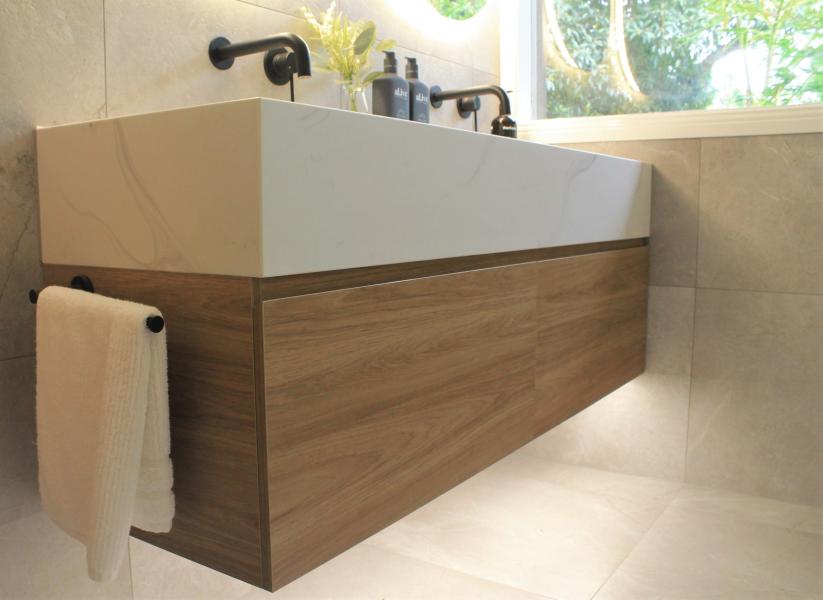 Wall-hung timber bathroom vanity with white basin and black tapware