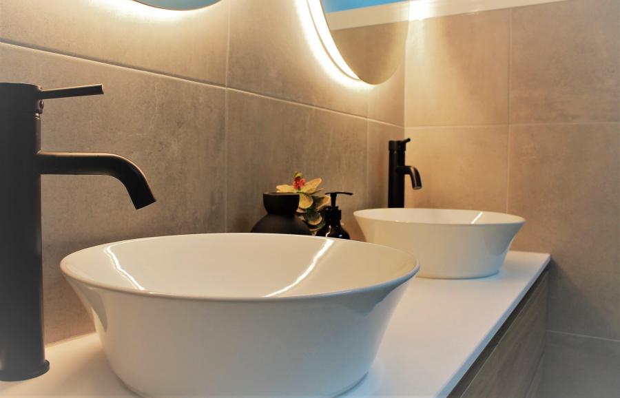 Double white vessel basins with matte black tapware in a modern bathroom vanity