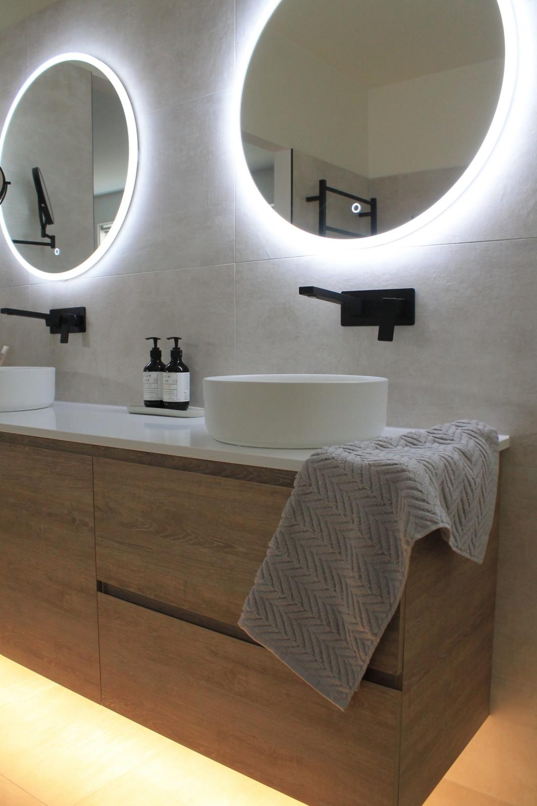 Modern bathroom vanity with dual LED illuminated mirrors and black tapware