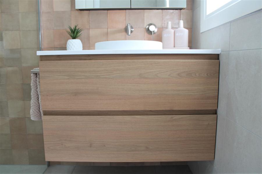 Wall-hung timber bathroom vanity with white basin in a modern tiled bathroom