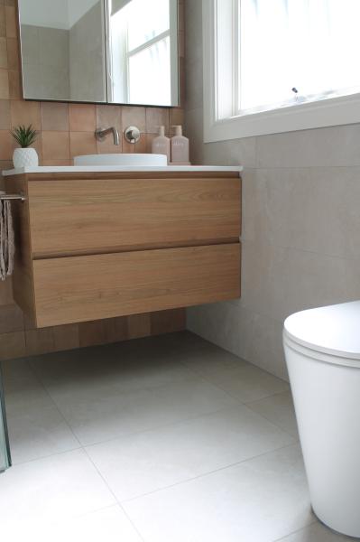 Modern bathroom with floating timber vanity, vessel basin and wall-faced toilet