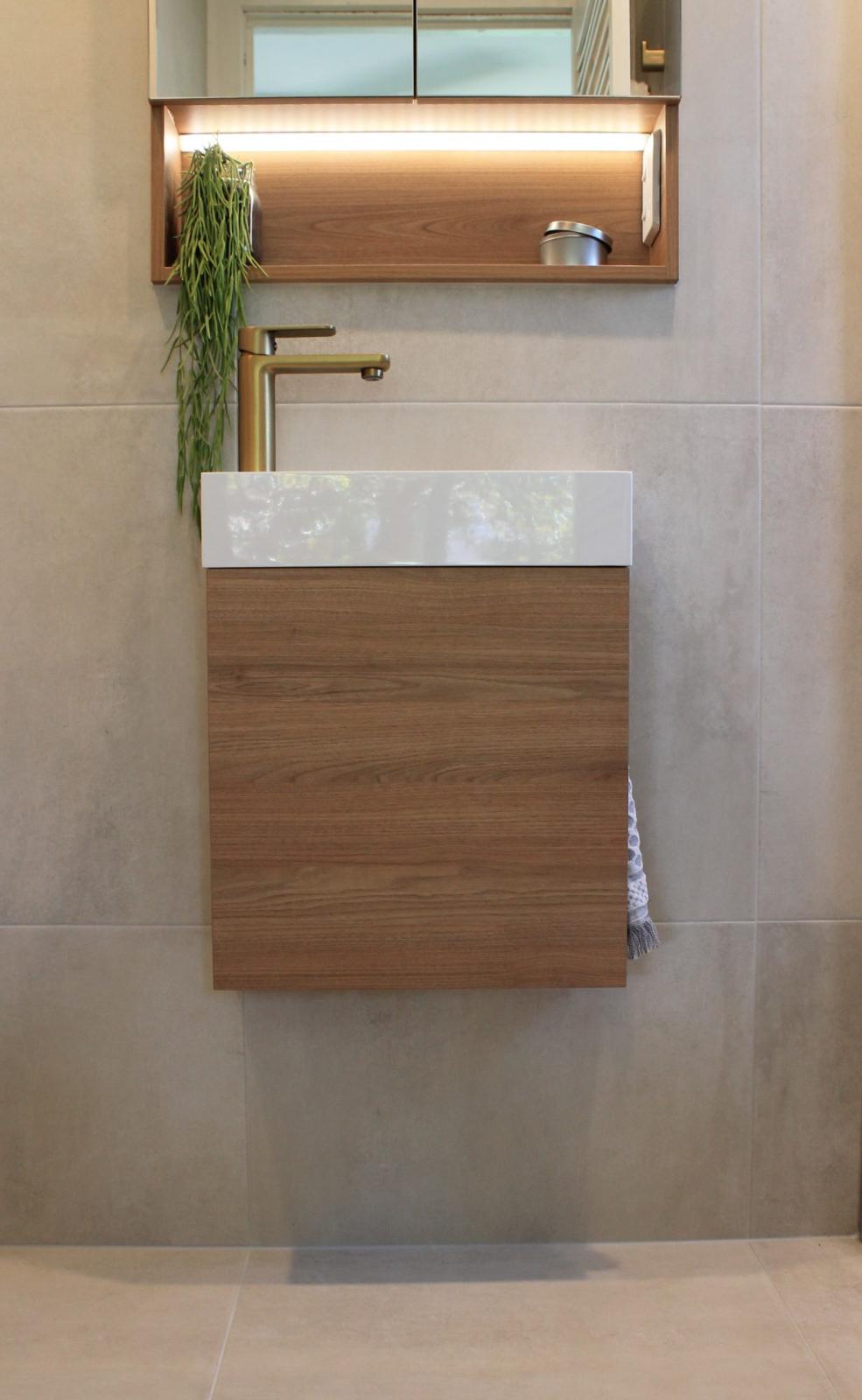 Modern bathroom vanity with timber cabinetry and brass tapware