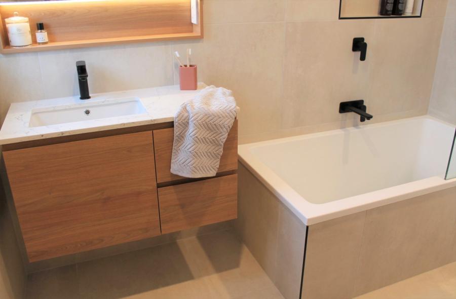 Modern bathroom with timber floating vanity, basin and bath with black tapware