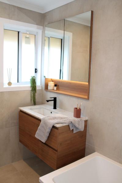 Modern bathroom vanity with stone basin, mirror cabinet and soft lighting