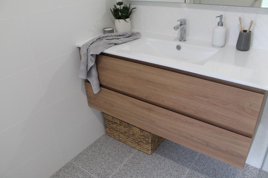 Floating timber vanity with white basin, mirror and bathroom accessories