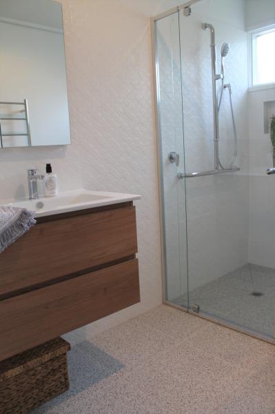 Modern bathroom with timber vanity, white basin and frameless glass walk-in shower