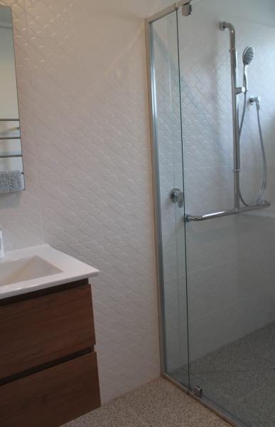 Modern bathroom with timber vanity and frameless glass shower enclosure
