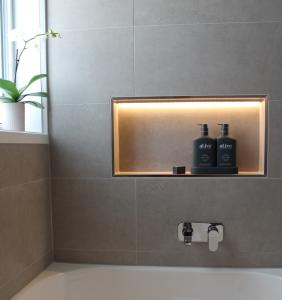 Modern bathroom shower niche with illuminated display and toiletries