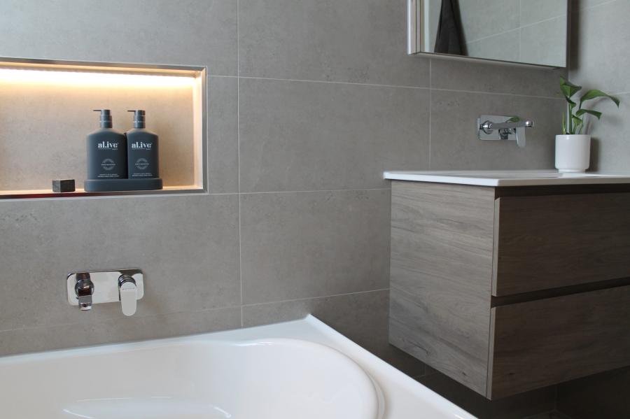 Modern bathroom with built-in bath, recessed niche and floating timber vanity