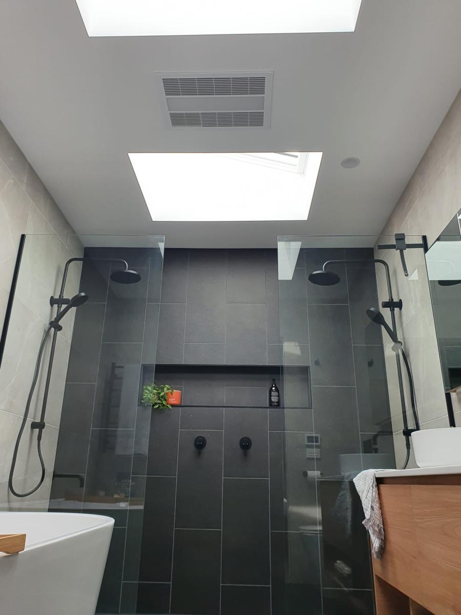 Modern ensuite with dual showers and black tiling
