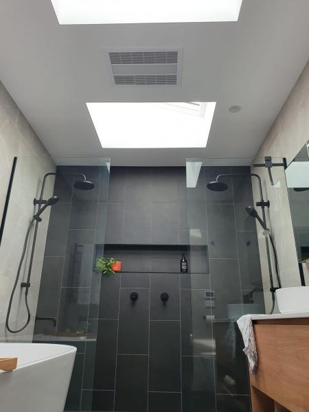 Modern ensuite with dual showers and black tiling