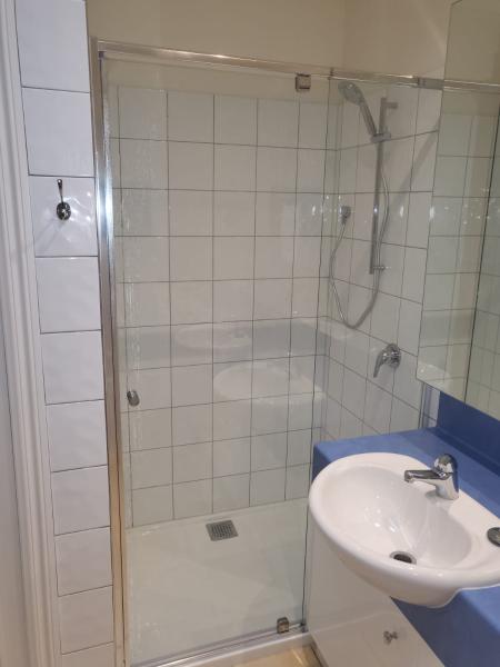 Modern bathroom with glass shower enclosure and white basin