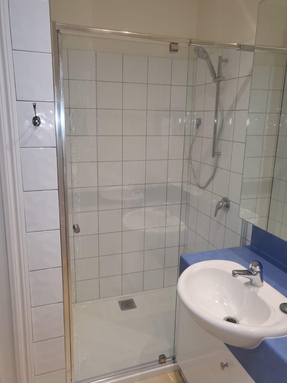 Modern bathroom with glass shower enclosure and white basin