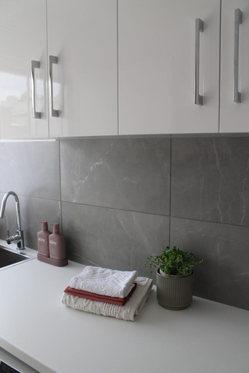 Modern bathroom vanity with grey tiling and white cabinetry