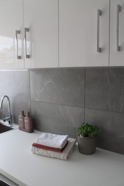 Modern bathroom vanity with grey tiling and white cabinetry