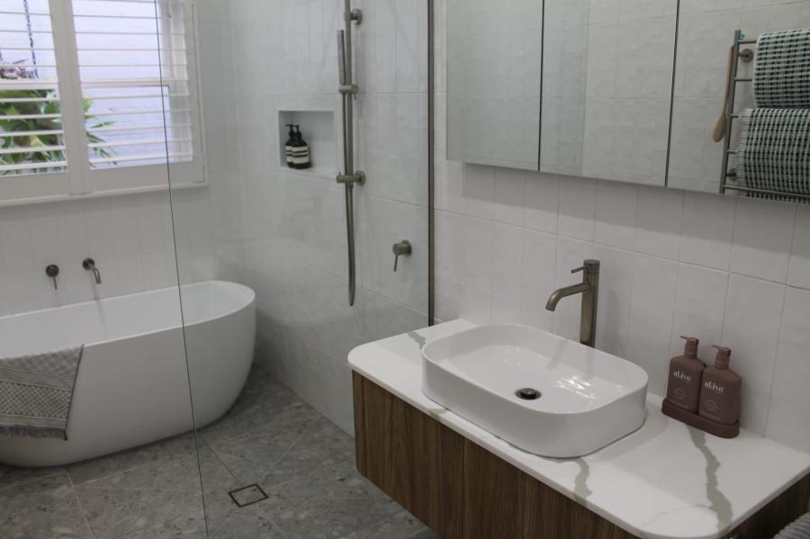 Modern white bathroom with freestanding bath, walk-in shower and timber vanity