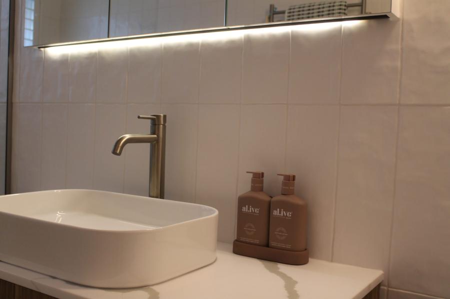 Modern bathroom vanity with vessel basin, chrome tap and soft under-cabinet lighting