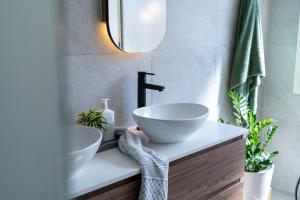 Modern bathroom vanity with white bowl sink and black tapware