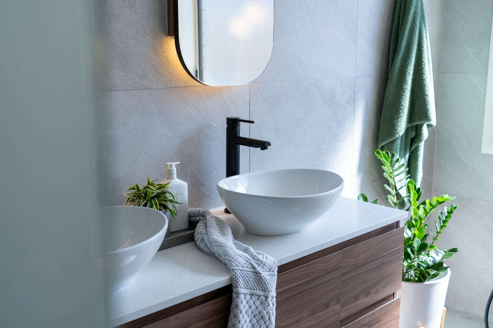 Modern bathroom vanity with white bowl sink and black tapware