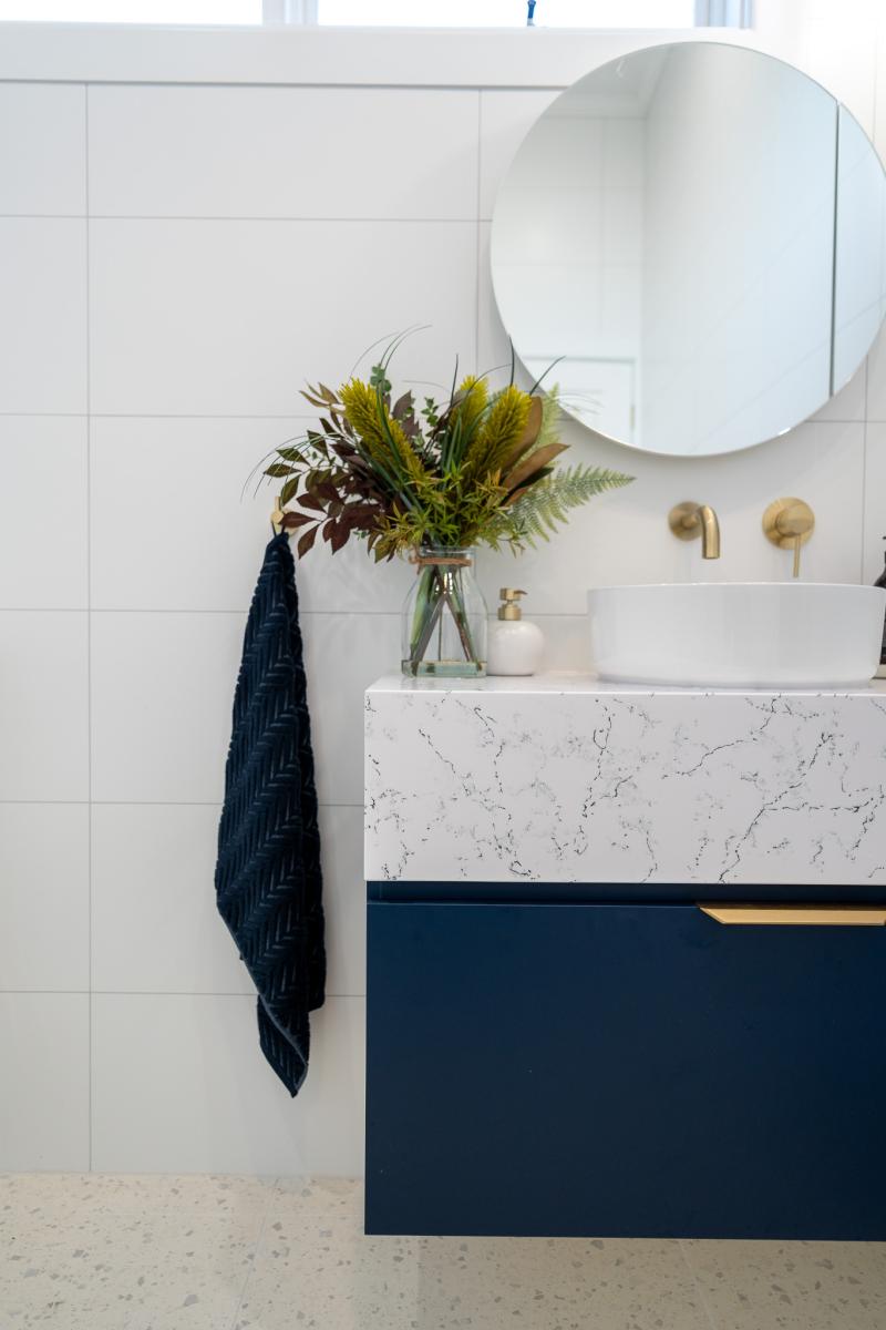 Modern bathroom vanity with marble countertop and round mirror