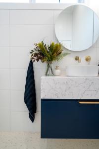 Modern bathroom vanity with marble countertop and round mirror
