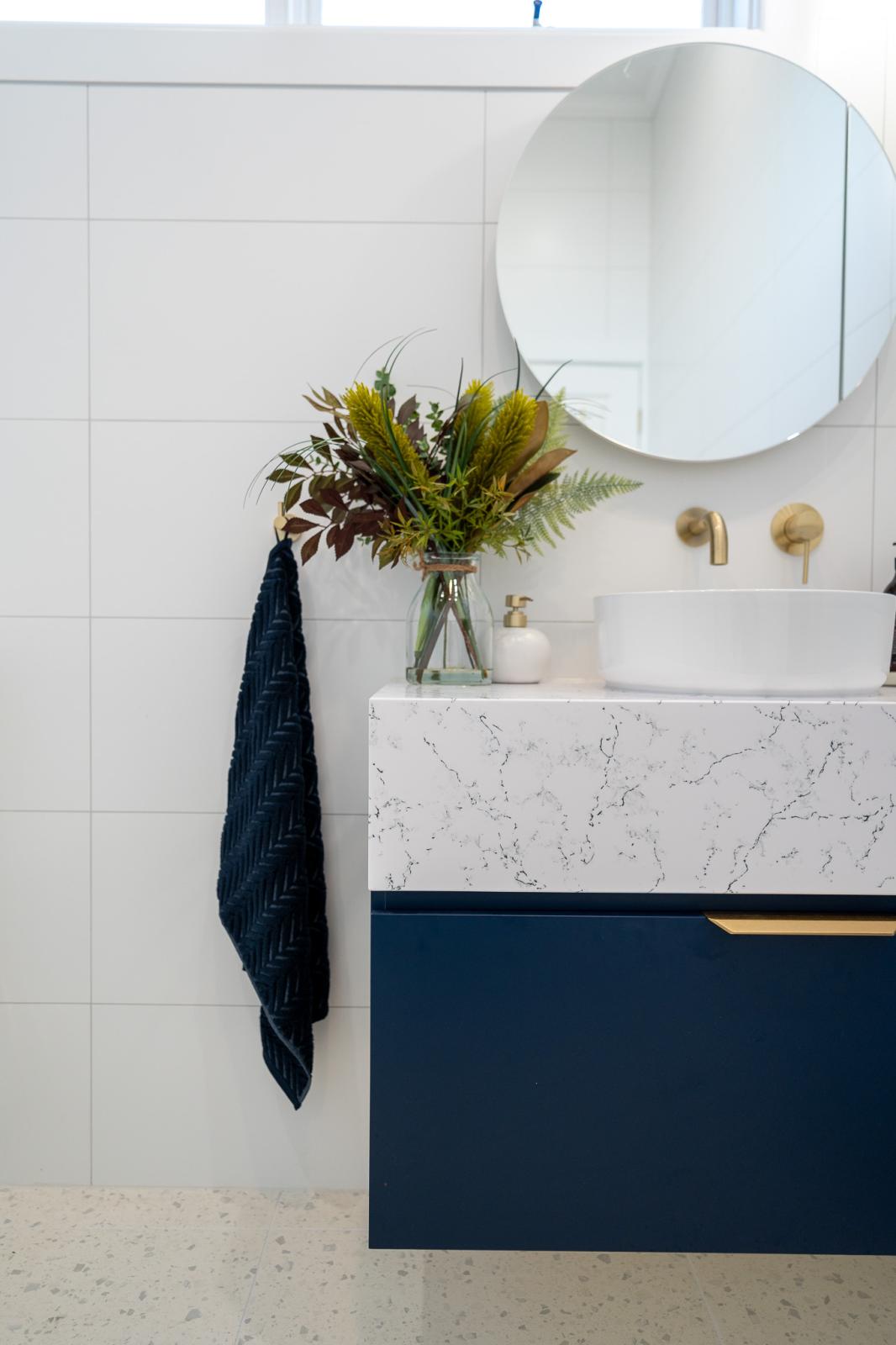 Modern bathroom vanity with marble countertop and round mirror