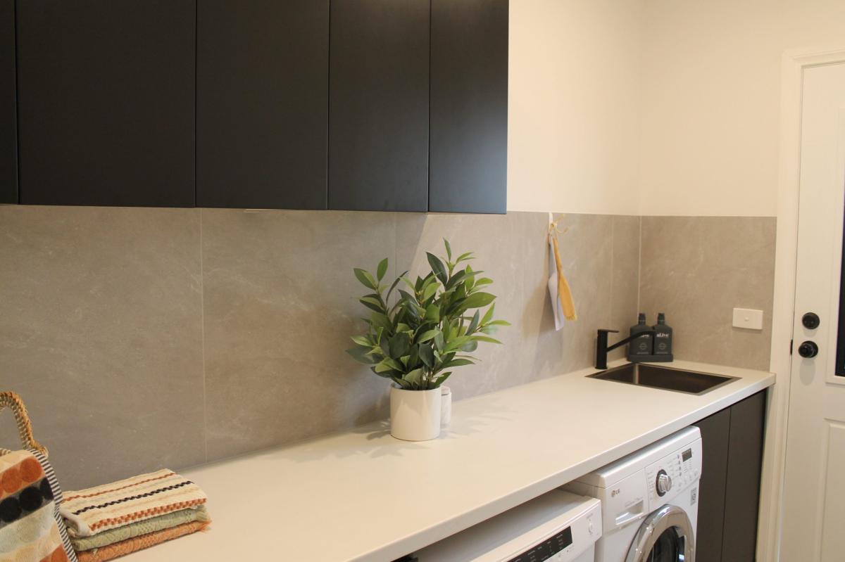 Modern laundry room with washing machines and splashback tiles
