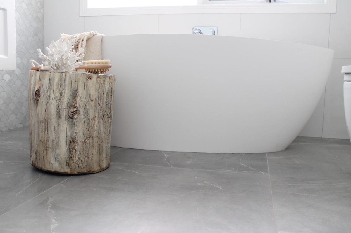 Modern white freestanding bath with grey tile flooring