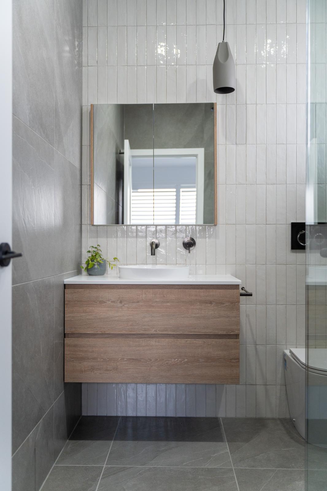 Modern bathroom vanity with timber cabinetry and mirror