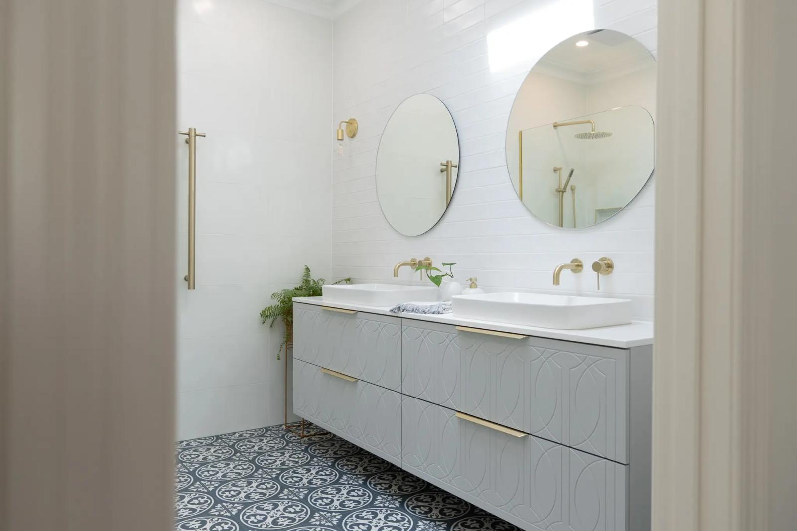 Modern bathroom with double vanity, brass tapware, round mirrors